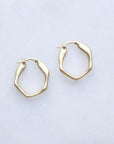 Gold hoop earrings on a light gray background