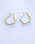 Gold hoop earrings on a light gray background