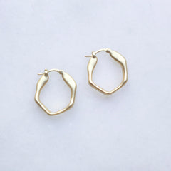 Gold hoop earrings on a light gray background